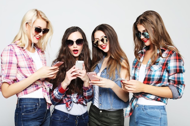 Amici di donne felici che condividono i social media in uno smartphone