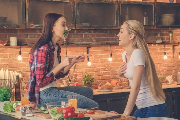 Amici di giovani donne che cucinano insieme a casa