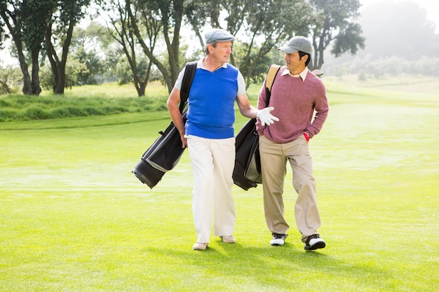 Amici di golfista camminando e chiacchierando