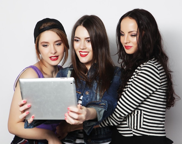 Amici di ragazze che prendono selfie con la compressa digitale
