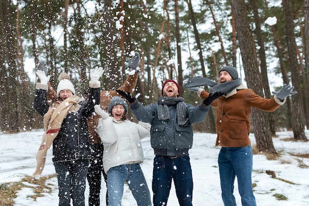 Amici di tiro medio che giocano con la neve