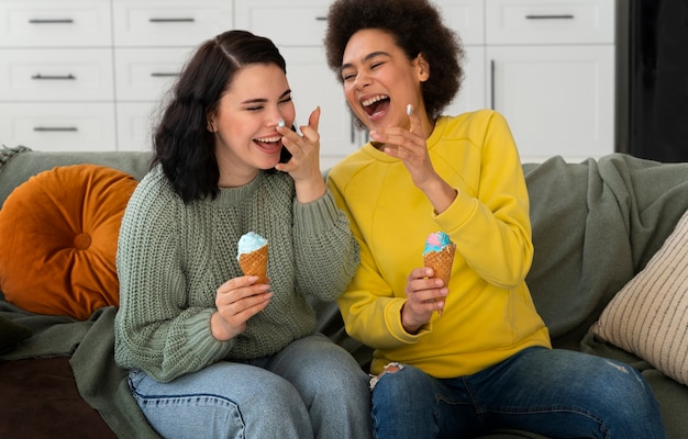 Amici di tiro medio che mangiano gustosi gelati