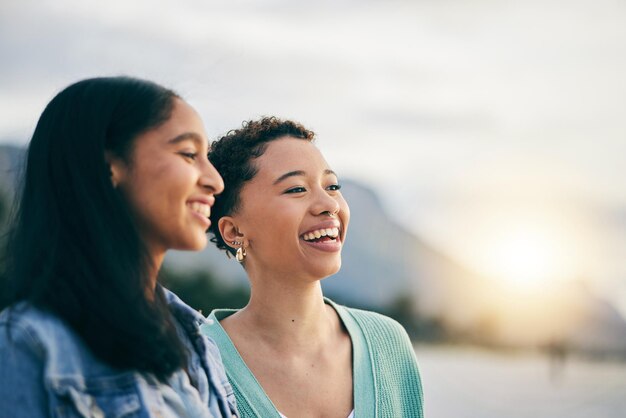 Amici donne gay o coppia con amore all'aperto al tramonto in estate Sorriso di LGBTQ o persone lesbiche in natura per la libertà vacanze studentesche e viaggi o appuntamenti con partner africano e spazio nel cielo