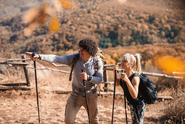 Amici escursioni sulla montagna. Uomo che punta al modo giusto. Zaini sul retro.