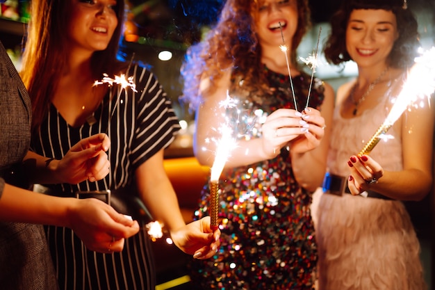 Amici felici che applaudono e bevono cocktail godendosi la festa nel club Concetto di stile di vita giovanile