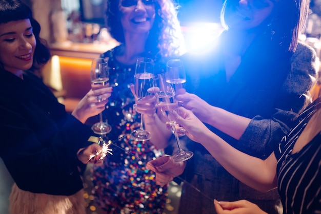Amici felici che applaudono e bevono cocktail godendosi la festa nel club Concetto di stile di vita giovanile