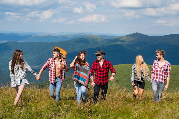 Amici felici che camminano sulla montagna. Escursione del fine settimana. Persone che si godono il picnic in una giornata di sole. Vacanze estive.