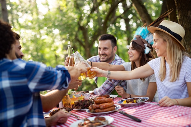 Amici felici che fanno barbecue e pranzano nella natura