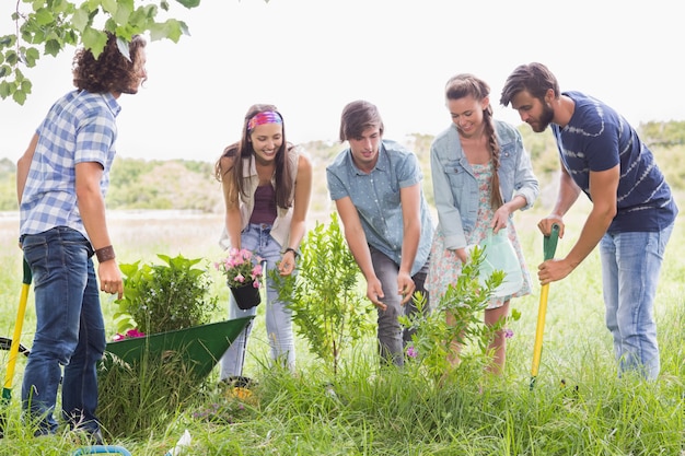 Amici felici che fanno giardinaggio per la comunità