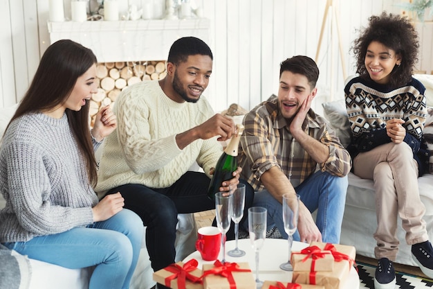 Amici felici che festeggiano il nuovo anno con champagne