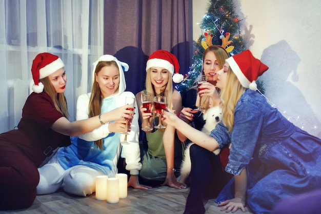 Amici felici che festeggiano il nuovo anno con un bicchiere di champagne e brindando a casa