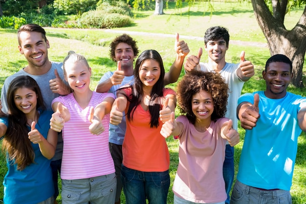 Amici felici che gesturing i pollici su