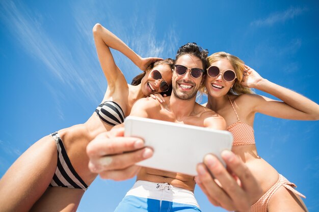 Amici felici che hanno divertimento sulla spiaggia