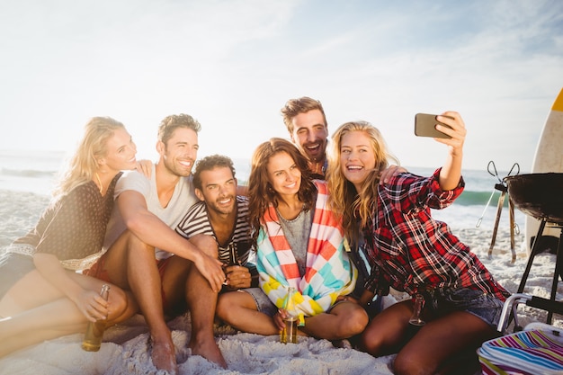 Amici felici che prendono selfie con lo smartphone