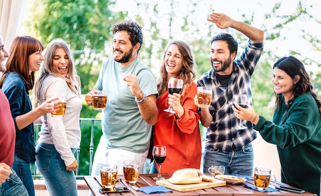 Amici felici che si divertono a mangiare a cena sul balcone di casa