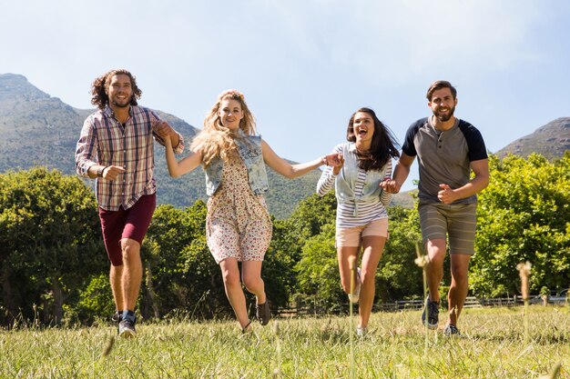 Amici felici che sorridono alla macchina fotografica e correre