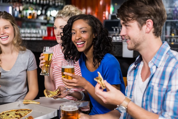 Amici felici con un drink e una pizza