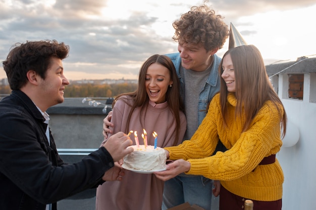 Amici felici del tiro medio con la torta