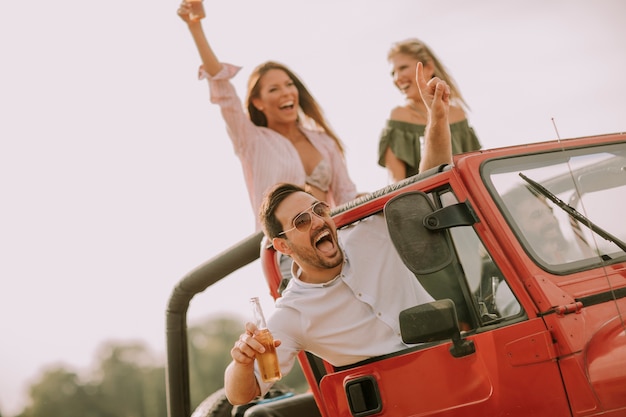 Amici felici divertendosi in auto convertibile in vacanza