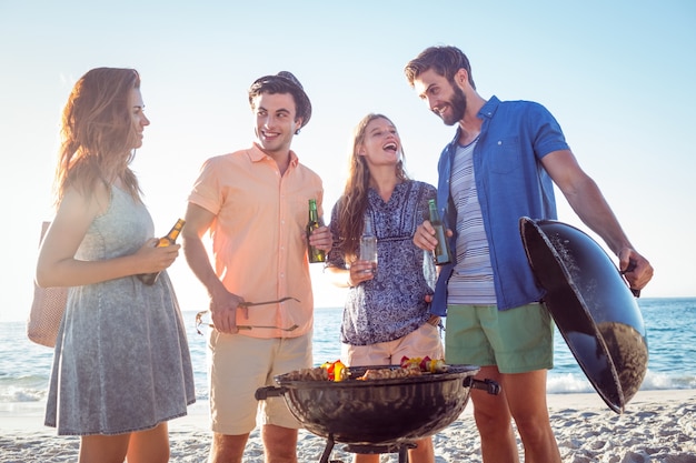 Amici felici facendo barbecue e bevendo birra