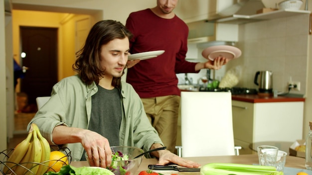 Amici felici in piedi vicino alla cucina a casa