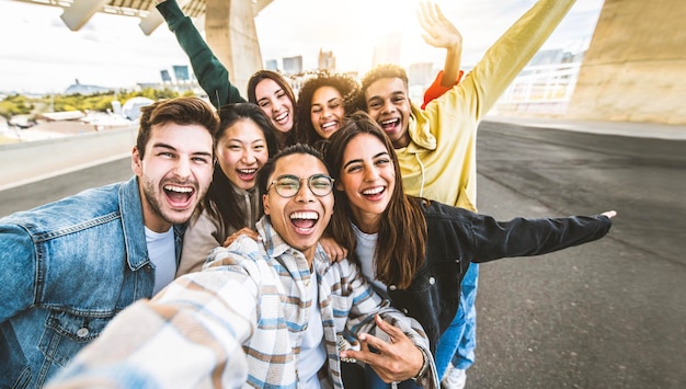 Amici felici multiculturali che si divertono a scattare foto selfie sulla strada della città