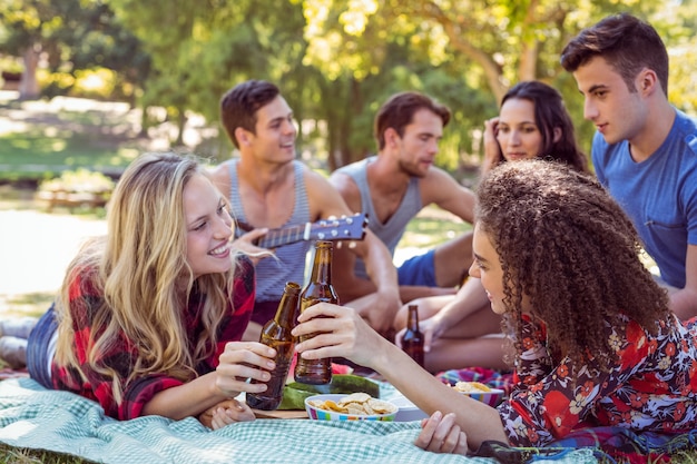 Amici felici nel parco che ha picnic