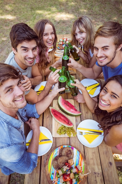 Amici felici nel parco che ha picnic