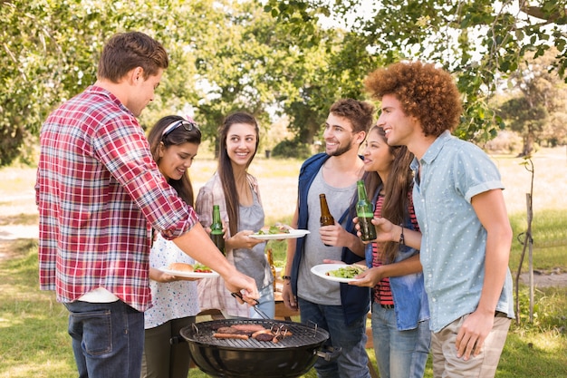 Amici felici nel parco con barbecue