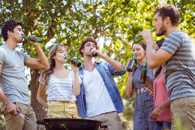 Amici felici nel parco con barbecue