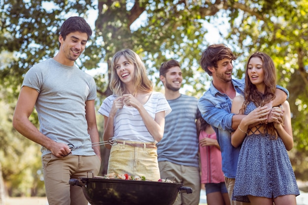 Amici felici nel parco con barbecue