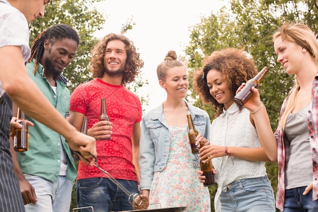 Amici felici nel parco con barbecue