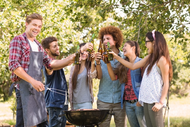 Amici felici nel parco con barbecue