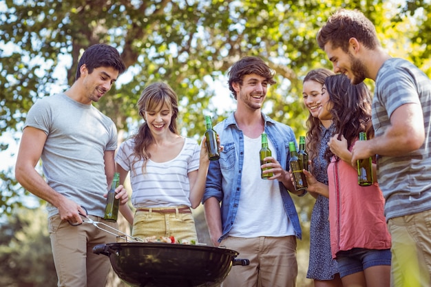 Amici felici nel parco con barbecue