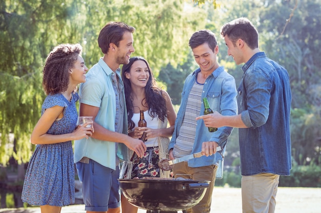 Amici felici nel parco con barbecue