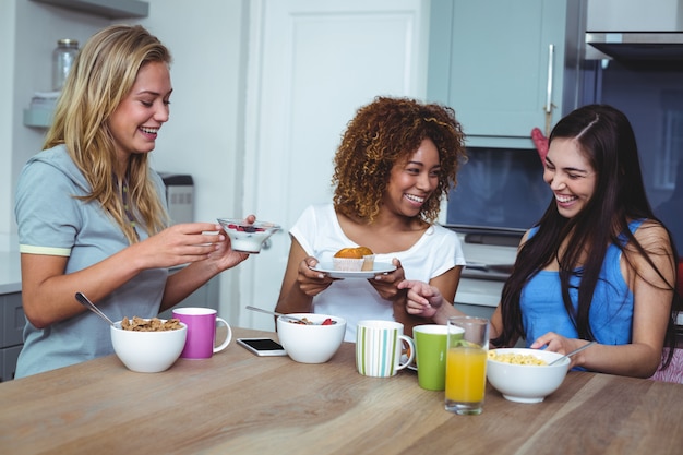 Amici femminili allegri che mangiano cibo