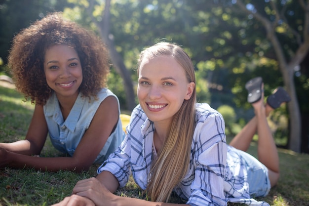 Amici femminili che si trovano insieme sull'erba nel parco