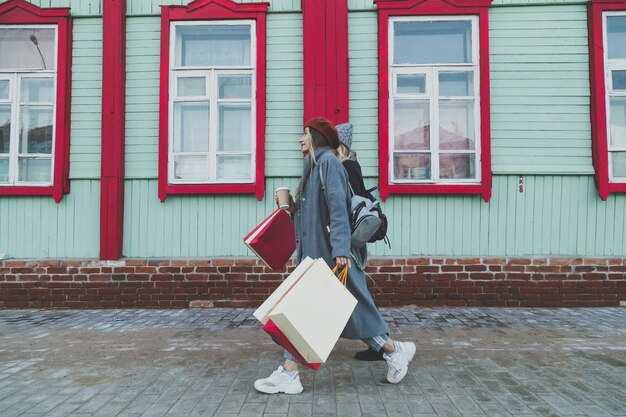 Amici femminili felici che comperano due belle giovani donne che si divertono a fare shopping in città con le borse della spesa