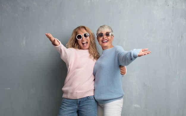 Amici femminili senior senior contro la parete del cemento di lerciume.