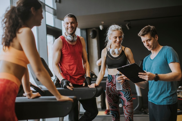 Amici in abiti sportivi parlando e ridendo insieme mentre riposa in palestra dopo un allenamento