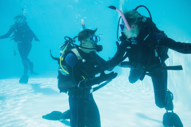 Amici in addestramento subacqueo immerso in piscina