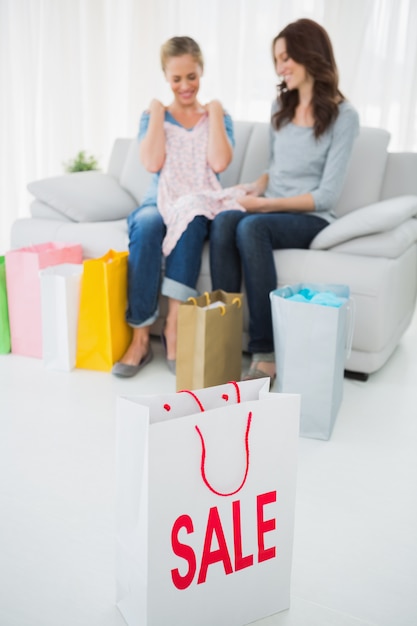 Amici in cerca di acquisto e shopping bag in primo piano