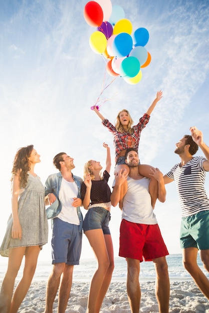 Amici in posa con palloncino sulla sabbia