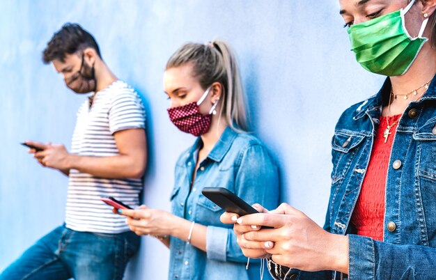 Amici miliari che utilizzano il telefono cellulare coperto dalla maschera facciale