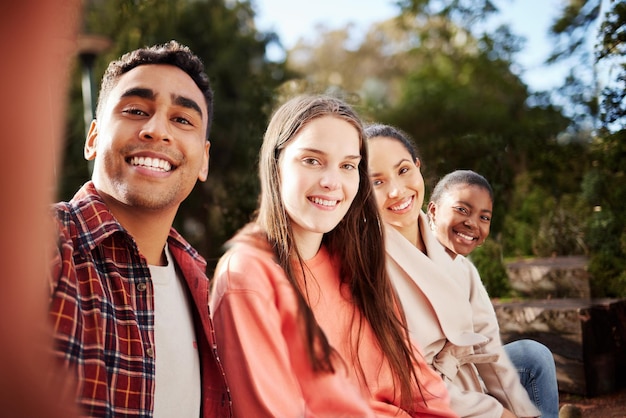 Amici nel campus Ritratto di quattro giovani studenti universitari che si fanno selfie seduti fuori nel campus durante la pausa