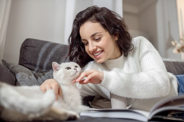 Amici. Proprietario dell'animale domestico femminile che sembra felice mentre passa il tempo con il suo gatto