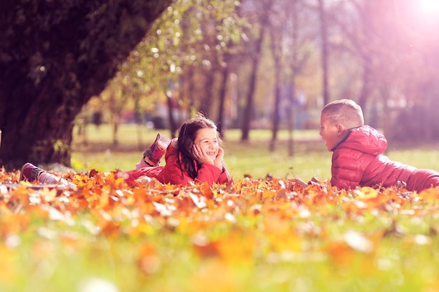Amici sdraiati su foglie al parco durante l'autunno