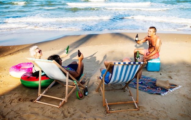 Amici senior bevendo un drink in spiaggia