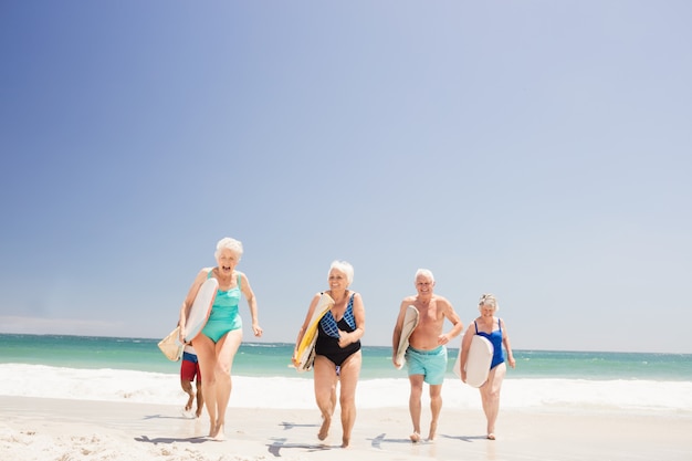 Amici senior che tengono tavola da surf