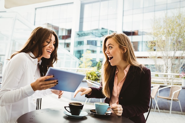 Amici sorpresi guardando tablet nel caffè